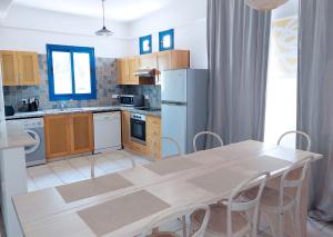 a kitchen with a table and chairs in a room at Azzurro Holiday Villas in Peyia