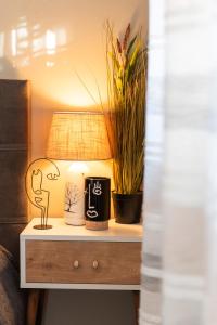 a nightstand with a lamp and plants on it at The Greens premium house - Luxury Apartment in the Heart of the City by Villa Mana Gers in Zakynthos Town