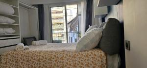 Schlafzimmer mit einem Bett und einem Fenster in der Unterkunft Appartement moderne à Nice, 50 m² avec balcon in Nizza