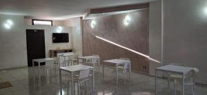 a room with tables and chairs and a television at B&B La Ninfa del Lago in Lesina