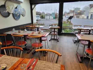 an empty restaurant with tables and chairs and a window at Auberge de Moussy proche Épernay in Moussy