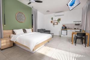a bedroom with a large bed and a kitchen at נופש Eylim-מתחם אירוח מהמם עם 3 סוויטות ובריכה מחוממת ומקורה in Sede Ẕevi