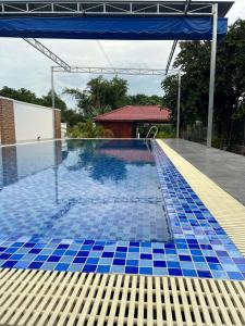 a swimming pool with blue tiles on the floor at Nha Trang Homestay Đồng Nai in Tân Phú