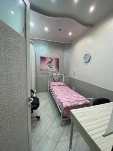 a small room with a bed and a table at Luxury Rosaverde in Frattamaggiore