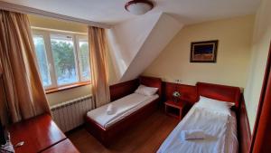 um pequeno quarto com duas camas e uma janela em La Dora Mountain Resort em Divčibare