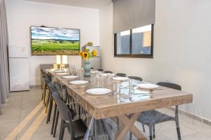 a large long table with chairs and a vase of flowers at נופש Eylim-מתחם אירוח מהמם עם 3 סוויטות ובריכה מחוממת ומקורה in Sede Ẕevi +31 photos