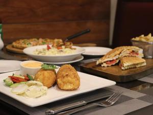 a table with plates of food on a table at Maisonette Firhill Hotel & Resort in Murree