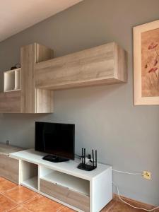 a living room with a tv on a white entertainment center at El Balcón de Peñiscola in Peñíscola