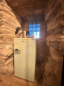 a refrigerator in a stone room with a window at La Finestra di Dante in Mulazzo