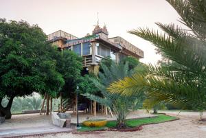 een gebouw met een palmboom ervoor bij Habba Dates Villa Near Chikkaballapur in Bāgepalli