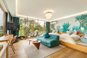 桂林市にあるGuilin Red Roof Garden Resort --Within 8000 square meter lush garden- Fluent English-Southeast Asian style decoration-Quiet and delightfulの大きなベッドと青いソファのある寝室