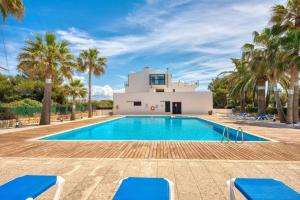una piscina frente a una casa con palmeras en Son Carrió 6, en Son Carrio