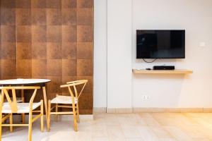 KokrobiteSerenity Residences & Spa - Kokrobite Beach的一间有桌椅和电视的餐厅