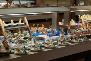 a buffet filled with plates of food on a table at TUI Magic Life Candia Maris - Adults Only in Amoudara Herakliou