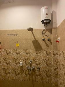 a bathroom with a shower with a hair dryer on the wall at Dreams Stay in Lucknow +71 photos
