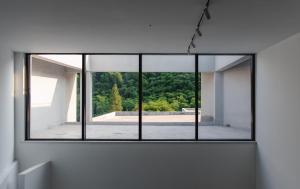 a window in a white room with a view of trees at Nian hotel & resorts in Huzhou