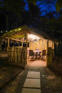 a table and chairs in a gazebo at night at Misty Hills Cabin in Wayanad