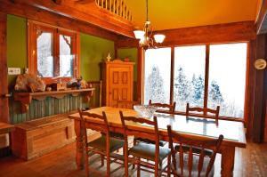 une salle à manger avec une table et des chaises en bois dans l'établissement Chalet de la Montagne, à Sainte-Rose-du-Nord