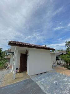 a small white house with a garage at Delima Cottage, a cozy studio in Melaka, Masjid Tanah in Masjid Tanah
