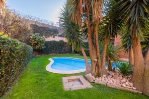 a swimming pool in a yard with palm trees at Eos Retreat in Trastevere with pool in Rome