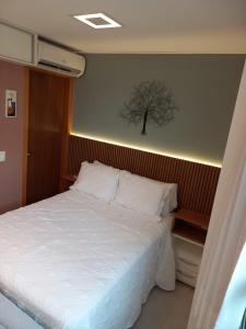 a bedroom with a bed with a tree on the wall at Flat Sudoeste Vienna by CentoEdez in Brasilia