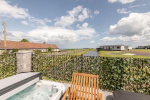 a balcony with a hot tub and a chair at Lodge No 9 - St Andrews Lodge Park in Strathkinness