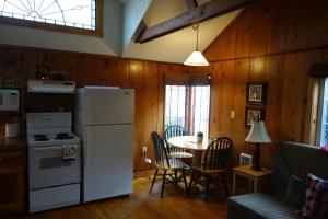 a kitchen with a white refrigerator and a table at Harrison Street Inn in Cannon Beach
