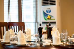 a table with wine bottles and napkins on it at Kenny Hotel Ha Long in Ha Long