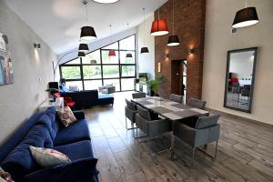 a living room with a blue couch and a table and chairs at Instytut Wypoczynku in Sulęczyno
