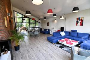 a living room with blue couches and a table at Instytut Wypoczynku in Sulęczyno