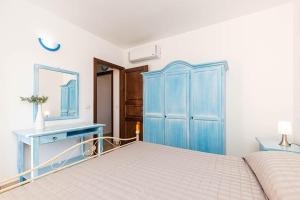 a blue bedroom with a bed and a blue dresser at ByNos Pool - Piano Terra in Santa Maria Navarrese