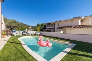a swimming pool with two pink flamingos in a yard at ByNos Pool - Piano Terra in Santa Maria Navarrese +8 photos