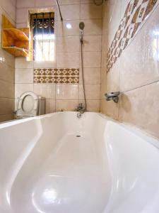 a large white bath tub in a bathroom at KAZ Appartment in Kampala +21 photos