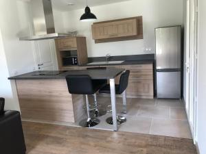 una cucina con tavolo con 2 sedie e frigorifero di Petite maison au calme avec piscine privative a Saint-Rémy-de-Provence