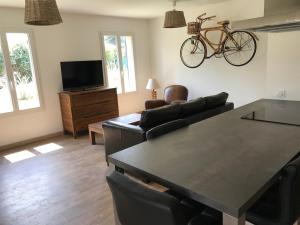 soggiorno con tavolo e bicicletta appesa al muro di Petite maison au calme avec piscine privative a Saint-Rémy-de-Provence