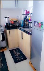 a small kitchen with a refrigerator and a stove at One bedroom apartment Aviv in Nairobi