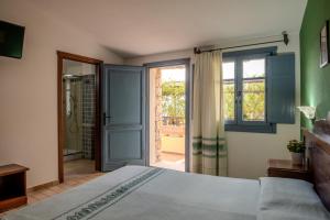 a bedroom with a bed and a sliding glass door at Hotel Bia Maore in Baunei