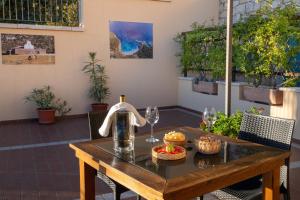 a table with wine glasses and food on a patio at Hotel Bia Maore in Baunei