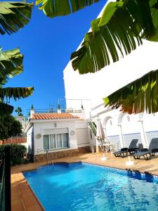 a villa with a swimming pool and a house at El Jardin BeNerja in Nerja