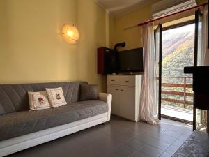 a living room with a couch and a television at La Casetta in Montagna by Holiday World in Lucoli Alto