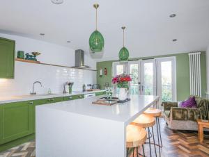 a kitchen with green cabinets and a white counter top at 34 Wexham Street in Beaumaris