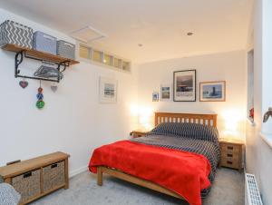 a bedroom with a bed with a red blanket at 34 Wexham Street in Beaumaris