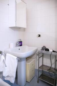 a white bathroom with a sink and a mirror at Cà di Rosa in Sestri Levante