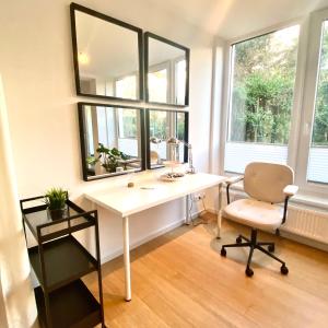 a white desk with a chair and a mirror at Romantisches 1 Zimmer-Apartment mit Garten an der Weser in Bremen