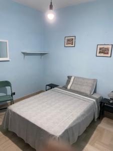 a bedroom with a bed and a blue wall at Appartamento Vittoria in Grotte