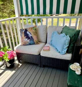 a wicker couch sitting on a porch at Wyobie Kangaroo Valley Treehouse in Kangaroo Valley +13 photos