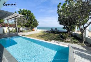 a swimming pool with a view of the ocean at lomme Private Beach House in Cha Am