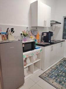 a kitchen with white cabinets and a microwave at AzzSpacesAnderson in Ipoh