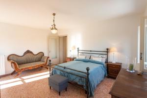 a bedroom with a bed and a chair and a table at La Dolcevita in Mombercelli