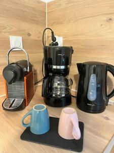 a counter top with a coffee maker and two coffee pots at Le petit refuge 28m2 2 personnes avec extérieur in Denain